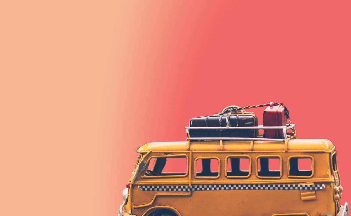 Une camionnette jaune, des valises sur le toit