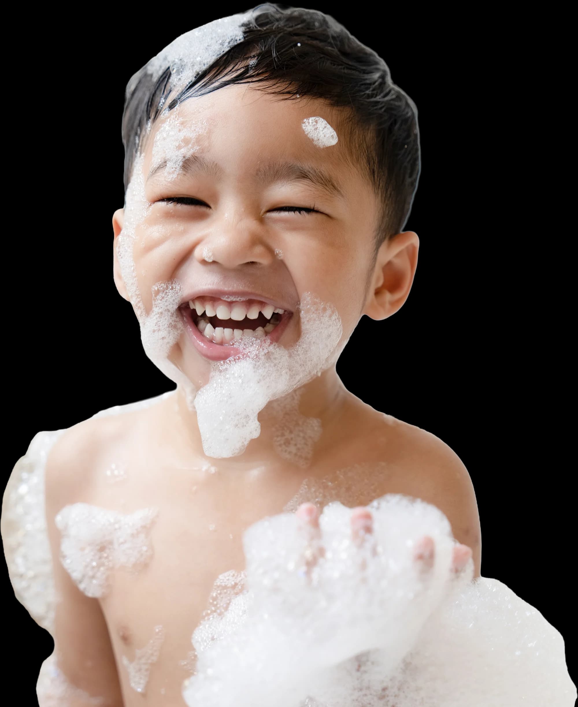Un petit garçon qui rit aux éclats, couvert de mousse de bain