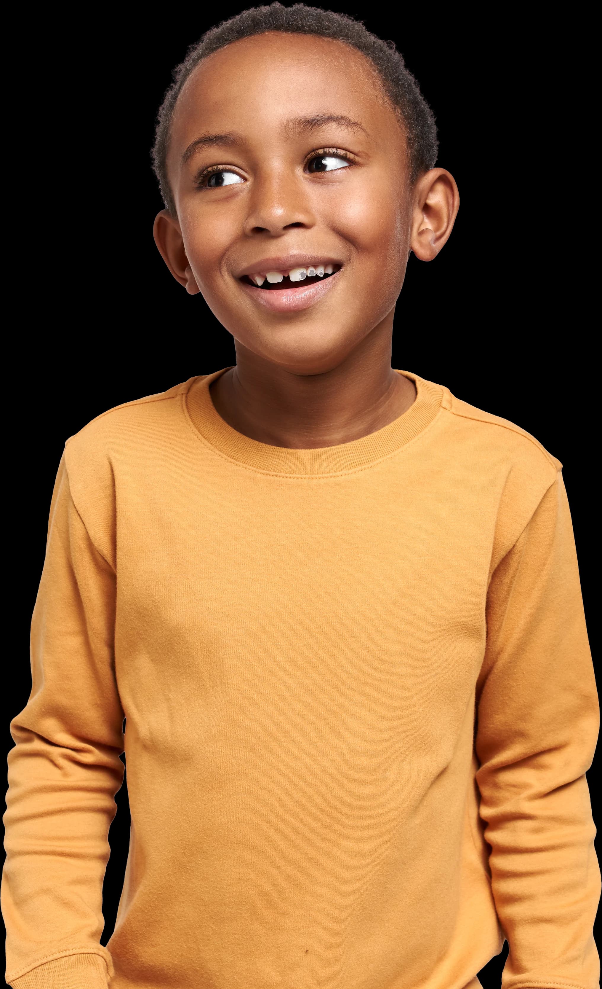 Un petit garçon souriant, qui regarde de côté