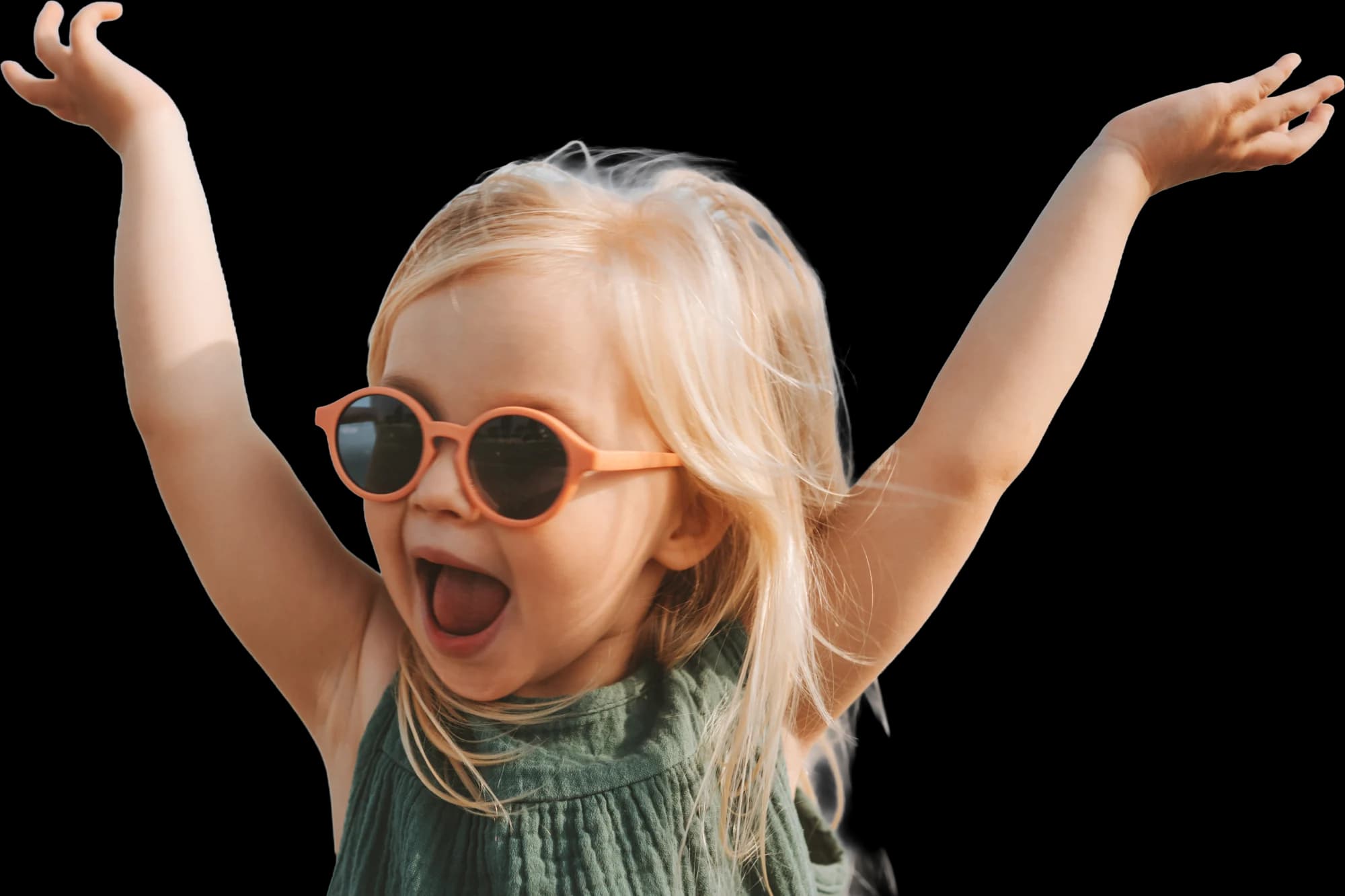 Une petite fille blonde en lunettes de soleil, les bras en l’air, qui crie de joie